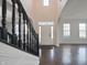 Light-filled foyer features wood floors, stair case with black railing, and arched doorways at 15201 Slateford Rd, Noblesville, IN 46062