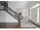 Light-filled foyer with hardwood floors, a staircase with black banister, and an open entryway at 15201 Slateford Rd, Noblesville, IN 46062