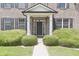 A welcoming front porch with a black door, framed by white pillars and manicured greenery at 15201 Slateford Rd, Noblesville, IN 46062