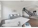 Open-concept living space with hardwood floors, a gray sofa, a staircase, and an archway to other rooms at 15201 Slateford Rd, Noblesville, IN 46062