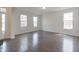 Bright, empty living room featuring hardwood floors, large windows, and freshly painted walls at 15201 Slateford Rd, Noblesville, IN 46062