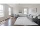 Bright living room showcasing hardwood floors, a gray sofa, and natural light streaming through large windows at 15201 Slateford Rd, Noblesville, IN 46062