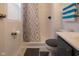This bathroom has a shower and tub, a toilet with gray fluffy cover, and a sink with a gray vanity at 1535 Whalen Ave, Indianapolis, IN 46227