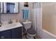 Bathroom featuring shower and tub, toilet, sink with vanity, mirror, and decorative towel rack and shelves at 1535 Whalen Ave, Indianapolis, IN 46227