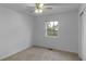 Bright bedroom with neutral carpet, ceiling fan, and a window offering a view of the outdoor landscape at 1535 Whalen Ave, Indianapolis, IN 46227