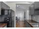 Kitchen with wood floors offers views into a dining room with natural light, gray painted cabinets and counters at 1535 Whalen Ave, Indianapolis, IN 46227