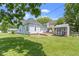 Backyard view featuring a well-maintained lawn, wooden deck, and a quaint shed at 1539 Evans Ave, Noblesville, IN 46060