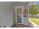 Close-up of front door featuring wreath, decor, and a welcome mat on the covered porch at 1539 Evans Ave, Noblesville, IN 46060