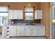Charming kitchen features white cabinets, neutral countertops, and a black tile backsplash at 1539 Evans Ave, Noblesville, IN 46060