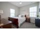 Inviting bedroom with a wood sleigh bed, two windows for natural light, and carpeted floors at 15557 Starflower Dr, Westfield, IN 46074