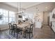 Open-concept dining area and living room with modern chandelier and large windows at 15557 Starflower Dr, Westfield, IN 46074