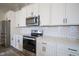 Close-up of a bright kitchen featuring white cabinets and modern appliances at 15557 Starflower Dr, Westfield, IN 46074