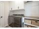 Well-organized laundry room with modern washer and dryer, white cabinets, and woven storage baskets at 15557 Starflower Dr, Westfield, IN 46074
