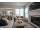 Open living room with cozy fireplace, neutral decor, and rustic coffee table at 15557 Starflower Dr, Westfield, IN 46074
