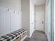 Mud room area with gray flooring, white wall paneling and a bench with storage baskets at 15557 Starflower Dr, Westfield, IN 46074