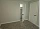 Bedroom with neutral walls and carpeting, showcasing closet and door at 1584 Shady Ln, Columbus, IN 47201