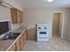 Functional kitchen boasts wooden cabinets, neutral countertop, and a white appliance package at 1584 Shady Ln, Columbus, IN 47201