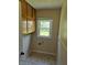Functional laundry room features cabinetry, a window for natural light, and washer/dryer hookups at 1584 Shady Ln, Columbus, IN 47201