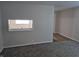 Living room showcasing neutral walls, plush carpeting, and a peek into the adjacent kitchen area at 1584 Shady Ln, Columbus, IN 47201