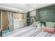 A basement bedroom with striped bedding, plush pillows, and a dark green accent wall at 1621 Beeler Ave, Speedway, IN 46224