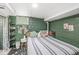 Basement bedroom featuring green concrete walls, and striped comforter at 1621 Beeler Ave, Speedway, IN 46224
