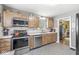 Efficient kitchen featuring stainless steel appliances, wooden cabinetry, and tile flooring at 1621 Beeler Ave, Speedway, IN 46224
