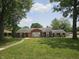 Traditional brick home featuring large front yard with mature trees and simple landscaping at 1628 Edgewood Dr, Anderson, IN 46011