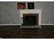 Close-up shot of fireplace with decorative mantel, and dark flooring in the empty living room at 1628 Edgewood Dr, Anderson, IN 46011