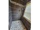 This sleek shower boasts dark tile walls, a mosaic tile accent, and a contrasting mosaic tile floor at 1628 Edgewood Dr, Anderson, IN 46011