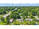 Expansive aerial view of suburban neighborhood with mature trees and glimpse of the city skyline in the distance at 17 E Beechwood Ln, Indianapolis, IN 46227