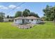 Well-maintained backyard featuring a patio, lush green grass, and mature trees at 17 E Beechwood Ln, Indianapolis, IN 46227