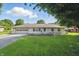Charming one-story brick home featuring an attached garage, green lawn, and mature trees at 17 E Beechwood Ln, Indianapolis, IN 46227