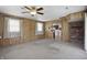 A living room with carpet, wood paneled walls, a ceiling fan, and a fireplace at 17 E Beechwood Ln, Indianapolis, IN 46227