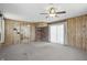 A living room with carpet, wood paneled walls, a ceiling fan, and a fireplace at 17 E Beechwood Ln, Indianapolis, IN 46227