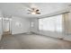 Bright living room with neutral carpeting, a ceiling fan, and an abundance of natural light at 17 E Beechwood Ln, Indianapolis, IN 46227
