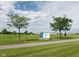Beautiful community sign with vibrant landscaping, mature trees and walking path at 174 Straughn Ln, Westfield, IN 46074
