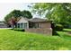 Exterior of home with lush green lawn and mature trees, brick accents and rear patio at 1783 Cloister Dr, Indianapolis, IN 46260
