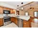 Well-lit kitchen with wooden cabinets, stainless steel appliances, and a breakfast bar overlooking the living room at 1783 Cloister Dr, Indianapolis, IN 46260
