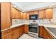 Updated kitchen with wood cabinets, stainless steel appliances, and tile backsplash at 1783 Cloister Dr, Indianapolis, IN 46260