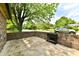 Outdoor patio surrounded by brick walls and mature trees at 1783 Cloister Dr, Indianapolis, IN 46260
