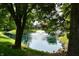 Scenic view of a pond with a fountain surrounded by lush trees and landscaping at 1783 Cloister Dr, Indianapolis, IN 46260
