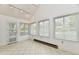 A sunroom with large windows offers plenty of light, tile floors, and a door to the outside at 1783 Cloister Dr, Indianapolis, IN 46260