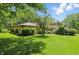 Well-manicured backyard with a vibrant green lawn, mature trees, and a brick home at 1914 S Avon Ave, Avon, IN 46123