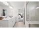 Bright bathroom offers dual sinks with quartz countertop, tile floors, a glass shower, and access to the bedroom at 19652 Shadow Trace Path, Westfield, IN 46074