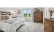 Calm bedroom featuring a comfortable bed, wooden dresser, and a window for natural light at 19652 Shadow Trace Path, Westfield, IN 46074