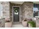 Charming front door with decorative wreath, brick facade, and potted plants adds curb appeal at 19652 Shadow Trace Path, Westfield, IN 46074