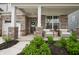 Inviting front porch with brick columns, cozy seating, and lush landscaping creates a welcoming entry at 19652 Shadow Trace Path, Westfield, IN 46074