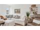 Bright living room featuring a large sectional sofa, ottoman, and a rustic accent table at 19652 Shadow Trace Path, Westfield, IN 46074