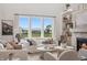 Bright and airy living room with a stone fireplace, comfortable seating, and a scenic backyard view at 19652 Shadow Trace Path, Westfield, IN 46074