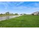 Peaceful view of pond with green grass and homes in the distance at 19652 Shadow Trace Path, Westfield, IN 46074